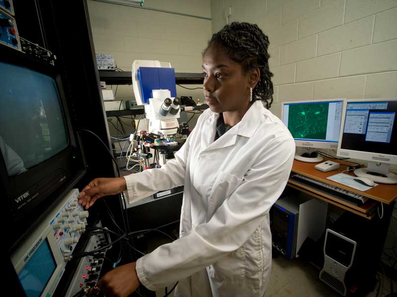 a researcher making adjustments to equipment in a research lab